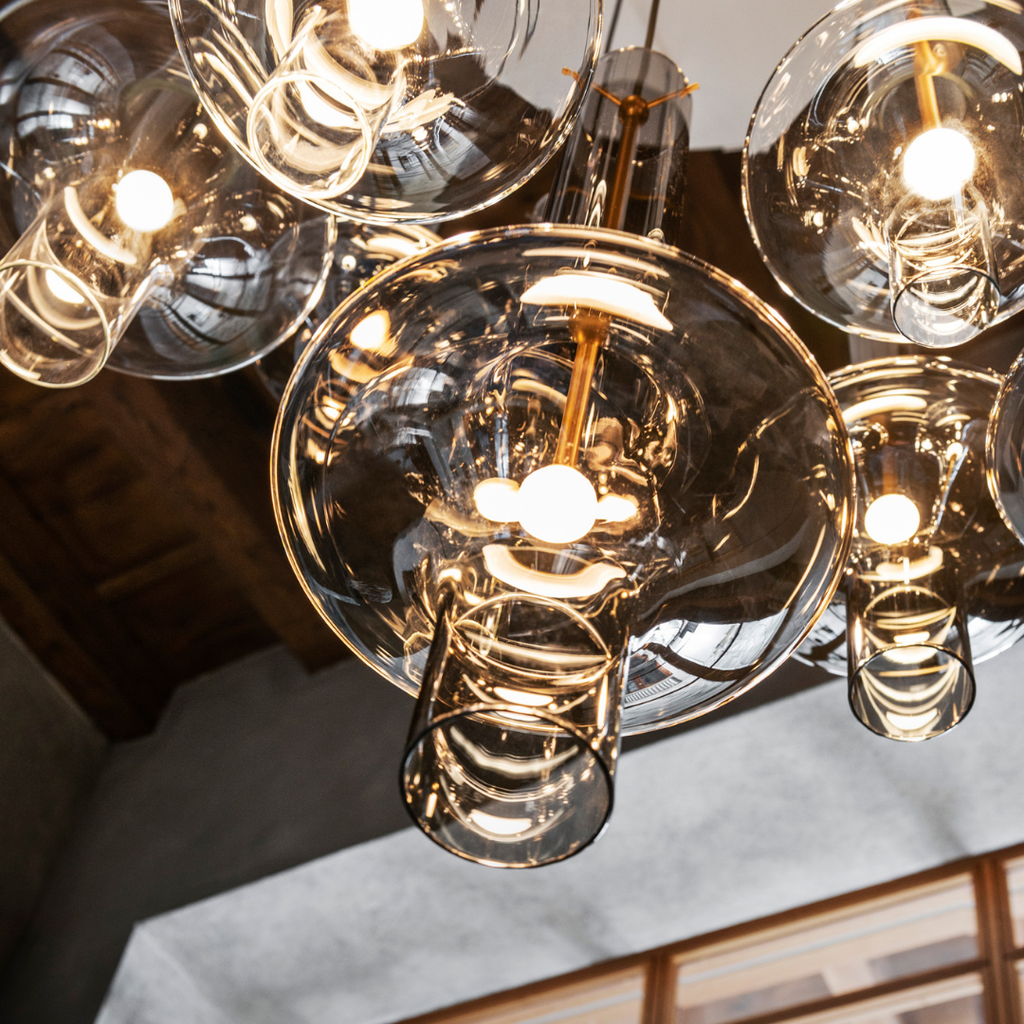 Penta Italian designer lighting featuring sculptural mirrored floor and pendant lights displayed in a luxury Singapore showroom